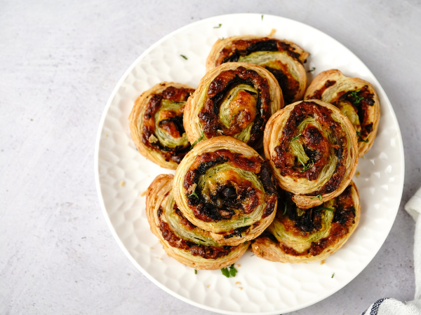 An overhead image of puff pastry pinwheels on a cake stand.